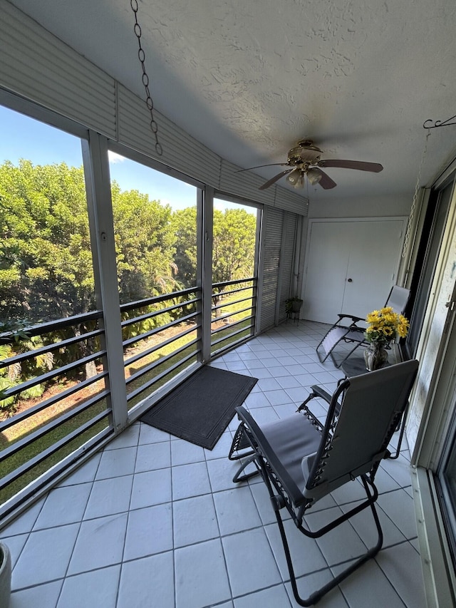 unfurnished sunroom with ceiling fan