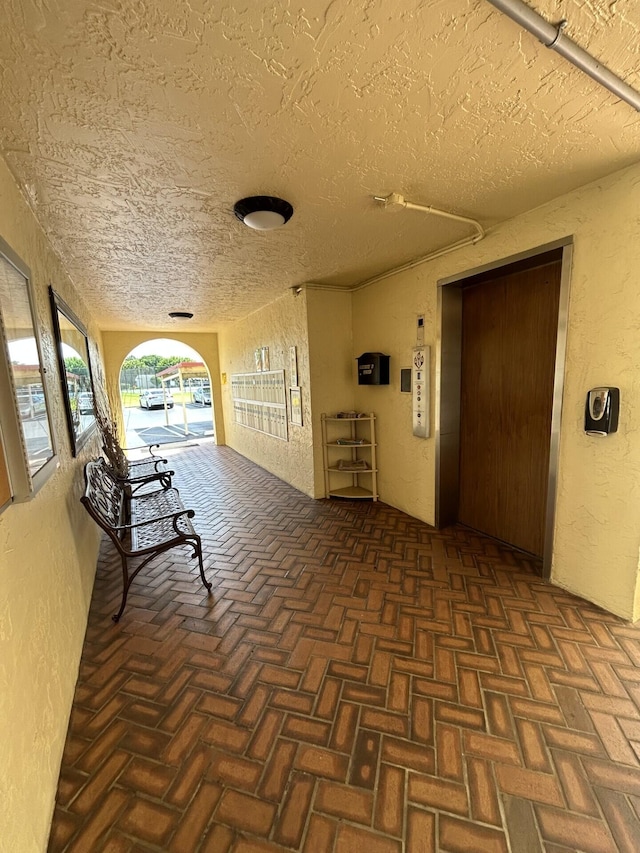 hall featuring a textured ceiling