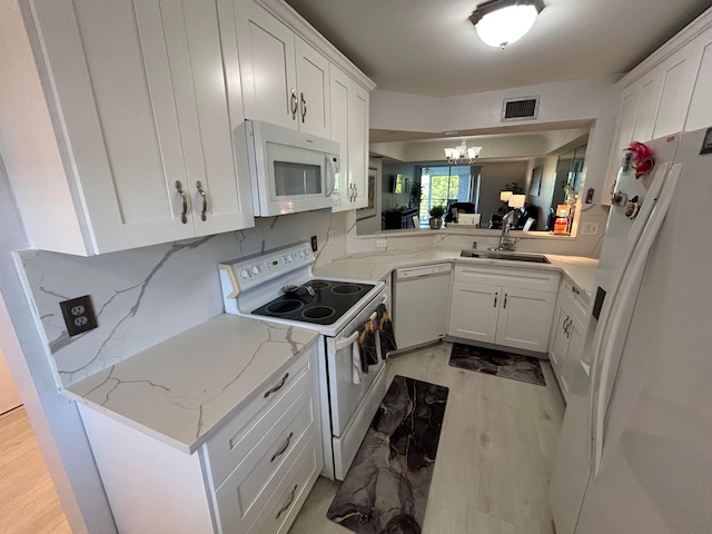 kitchen with white cabinets, light hardwood / wood-style flooring, sink, and white appliances