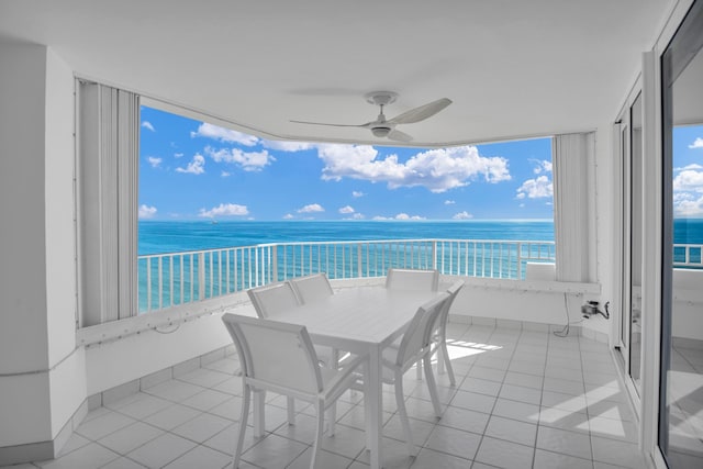 balcony with ceiling fan and a water view