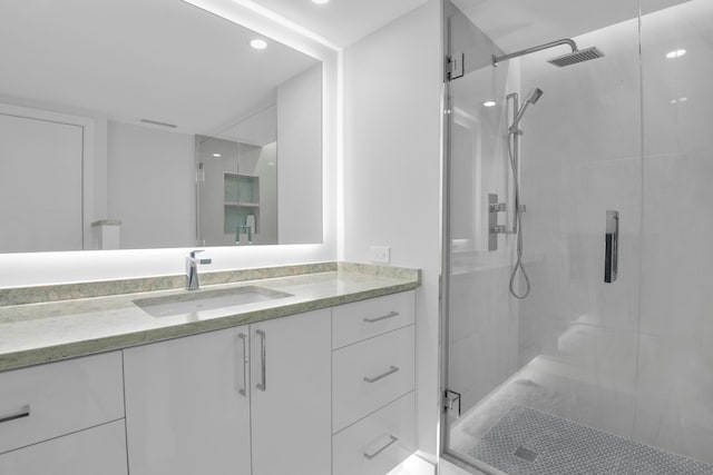 bathroom featuring tile patterned flooring, a shower with shower door, and vanity