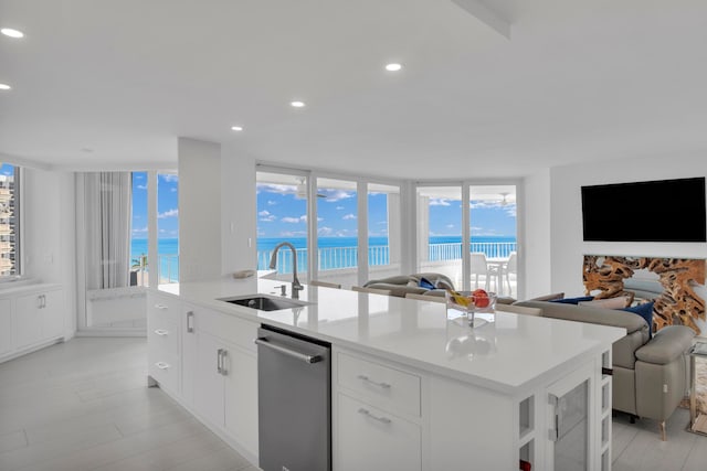 kitchen featuring white cabinets, stainless steel dishwasher, sink, and a wealth of natural light