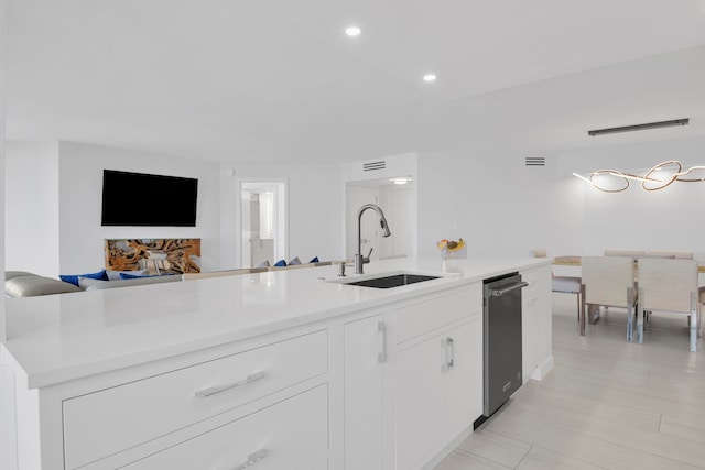 kitchen with a center island with sink, hanging light fixtures, sink, and white cabinetry