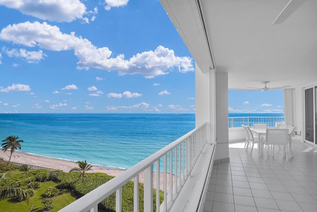 balcony featuring ceiling fan, a water view, and a beach view