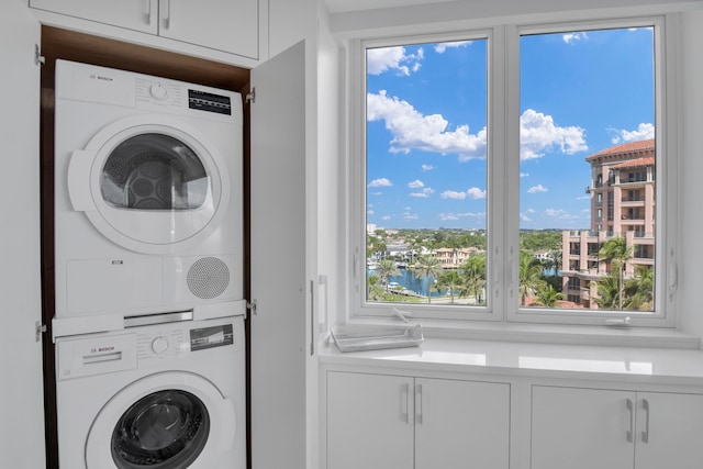 washroom with a healthy amount of sunlight and stacked washing maching and dryer