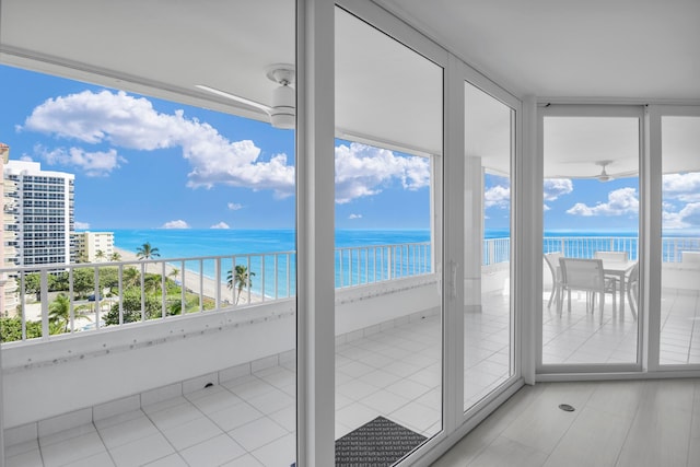 unfurnished sunroom with a water view and a view of the beach