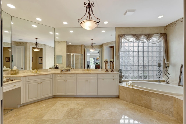 full bathroom featuring a stall shower, a garden tub, vanity, and recessed lighting