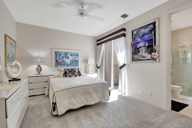 bedroom featuring light carpet, ceiling fan, and ensuite bath