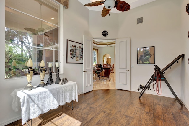 hallway featuring plenty of natural light, wood finished floors, visible vents, and baseboards