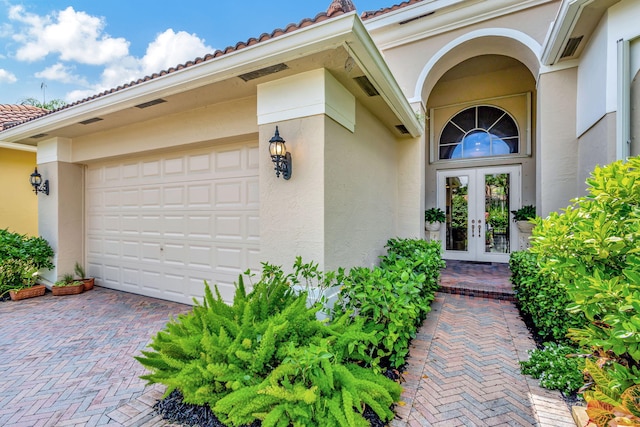 entrance to property with a garage and french doors