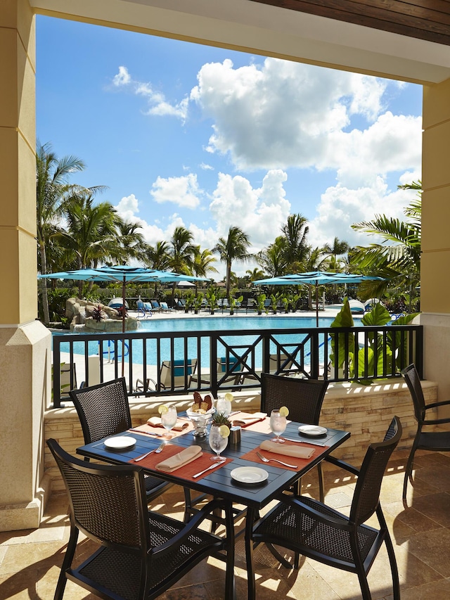 balcony with a water view and outdoor dining space