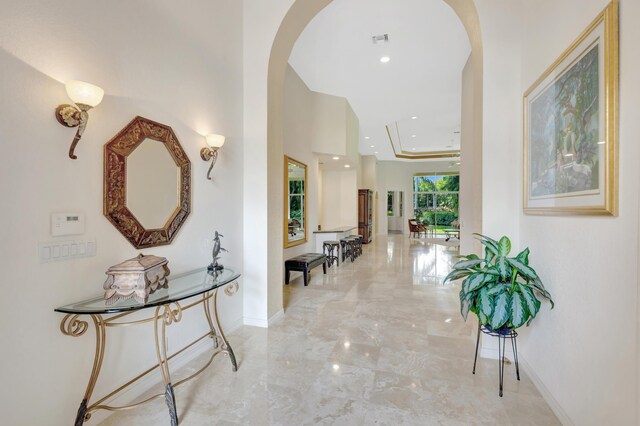 living area featuring marble finish floor, ceiling fan, and a raised ceiling