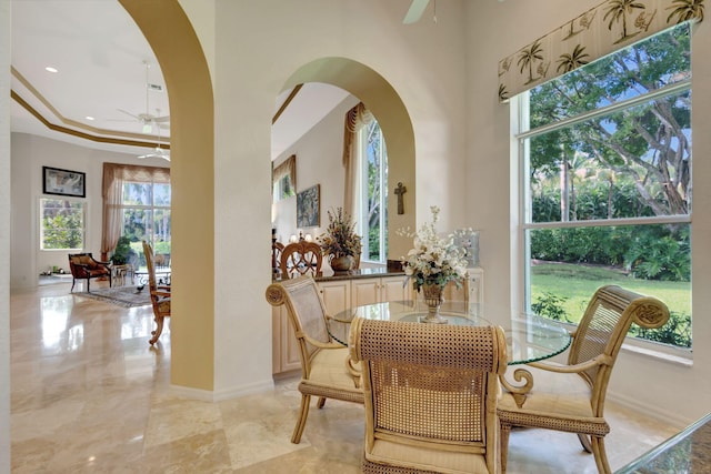 dining area with a ceiling fan, arched walkways, and a healthy amount of sunlight