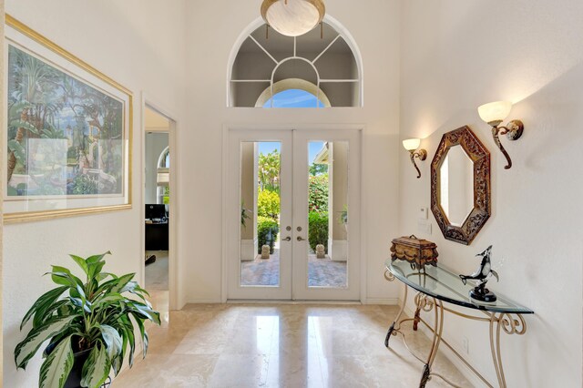 dining room featuring light hardwood / wood-style floors, beam ceiling, coffered ceiling, and a towering ceiling