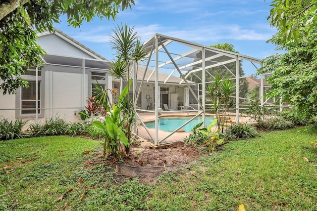 view of pool with a lanai and a yard