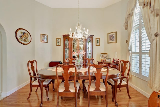 dining area with light hardwood / wood-style flooring and a chandelier