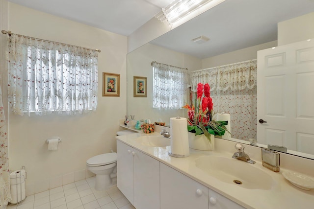 bathroom featuring vanity, toilet, tile patterned floors, and a wealth of natural light