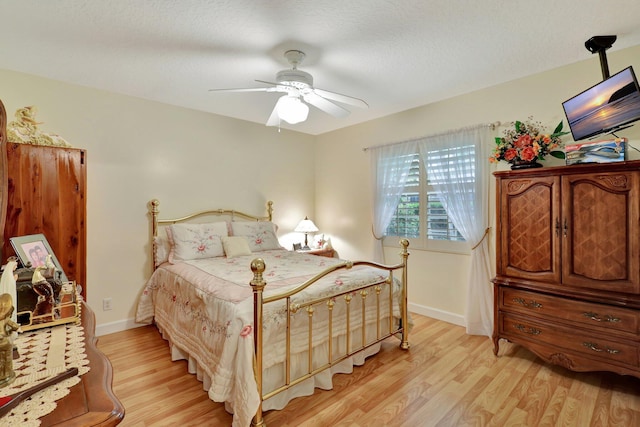 bedroom featuring ceiling fan, a textured ceiling, and light hardwood / wood-style flooring