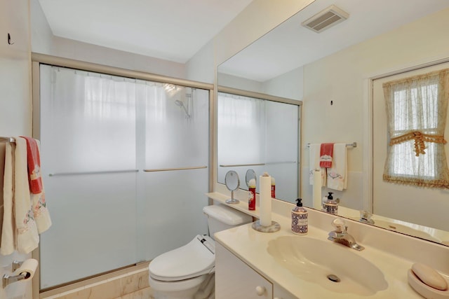 bathroom featuring vanity, toilet, and a shower with door