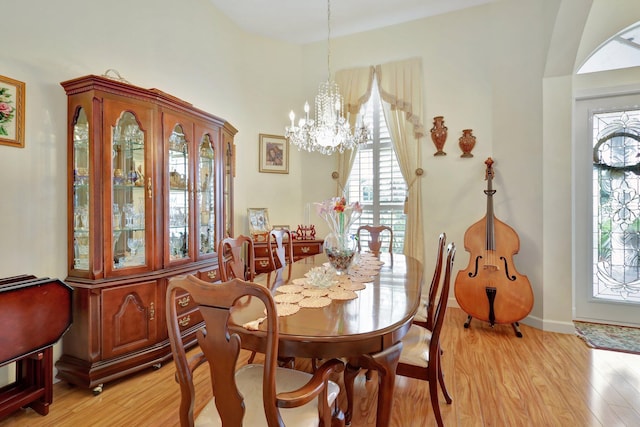 dining area featuring light wood-type flooring and a chandelier