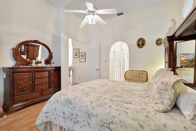 bedroom with a high ceiling, light hardwood / wood-style floors, and ceiling fan