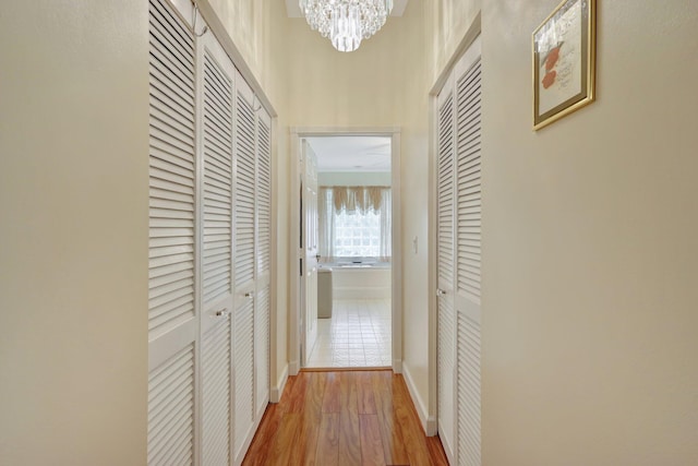 hallway with a notable chandelier and hardwood / wood-style floors