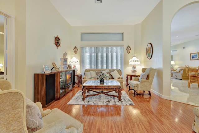 living room featuring a high ceiling and light hardwood / wood-style floors