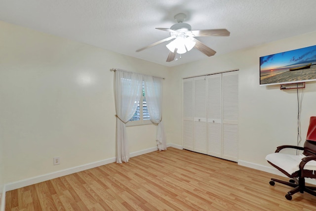 unfurnished office with a textured ceiling, ceiling fan, and light hardwood / wood-style flooring