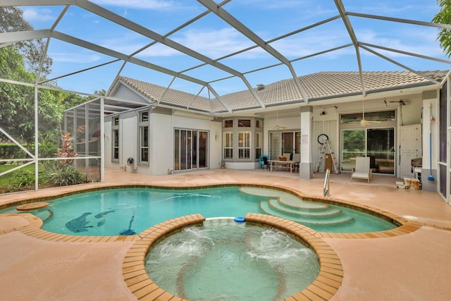 view of swimming pool with a lanai, ceiling fan, an in ground hot tub, and a patio area