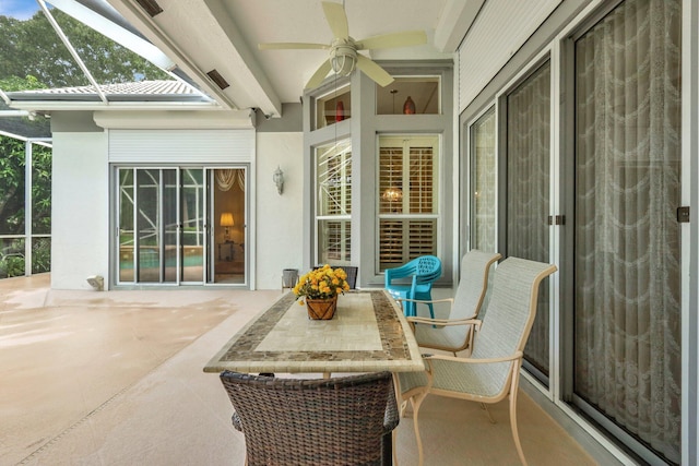 sunroom with ceiling fan and beamed ceiling