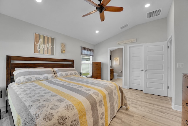 bedroom with ceiling fan, connected bathroom, vaulted ceiling, and light hardwood / wood-style flooring