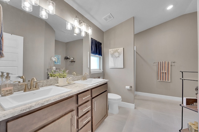 bathroom featuring vanity, vaulted ceiling, tile patterned floors, and toilet