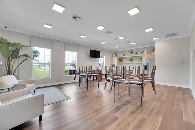 dining room featuring ornamental molding and light wood-type flooring