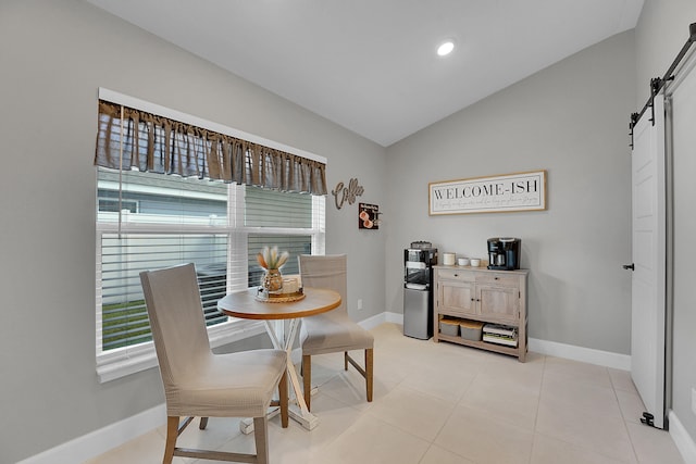 tiled dining room with lofted ceiling and a barn door