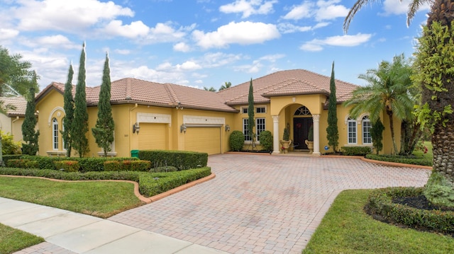 mediterranean / spanish-style home featuring a garage and a front lawn