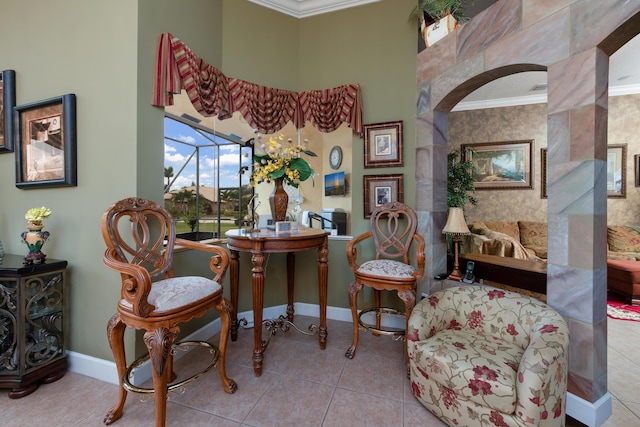 sitting room with a high ceiling, ornamental molding, and light tile patterned flooring