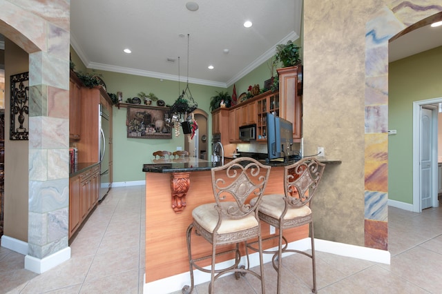 kitchen with crown molding, a kitchen breakfast bar, kitchen peninsula, and light tile patterned flooring