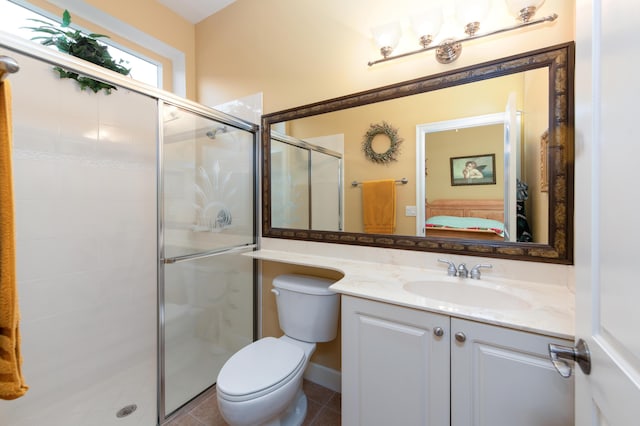 bathroom with vanity, a shower with shower door, tile patterned floors, and toilet