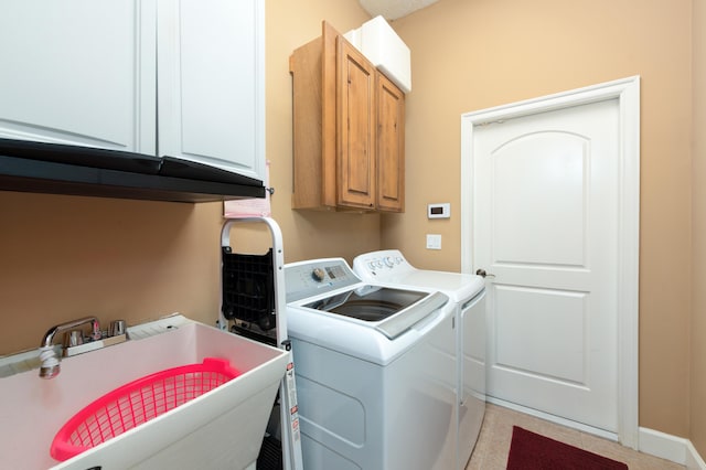 washroom with cabinets, sink, and washer and clothes dryer