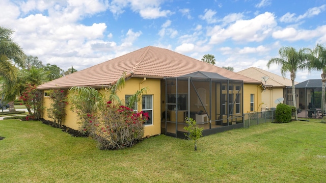 rear view of property with a yard and a lanai