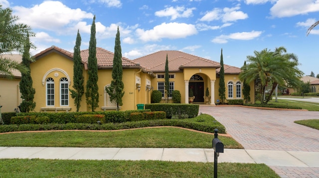 mediterranean / spanish home featuring a front yard