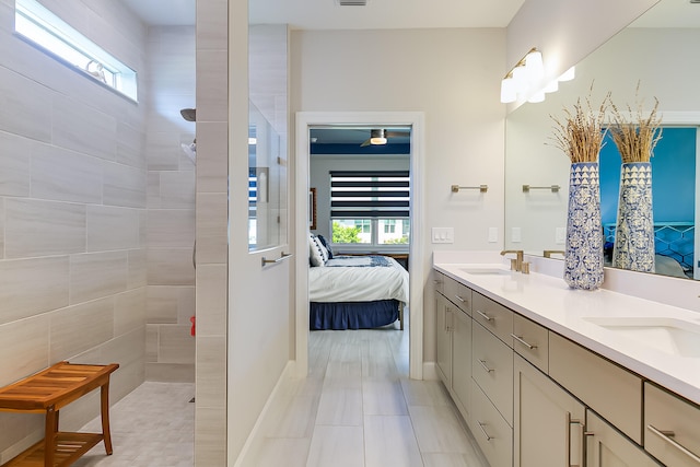 bathroom with vanity, tile patterned flooring, and tiled shower