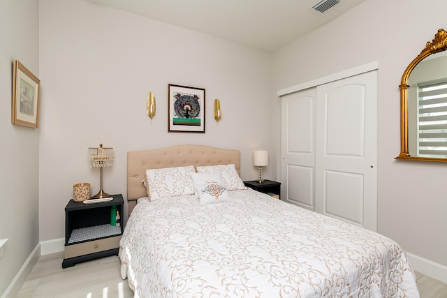 bedroom with light wood-type flooring and a closet