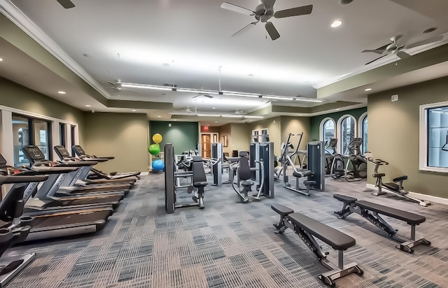 exercise room featuring a tray ceiling, ceiling fan, and crown molding