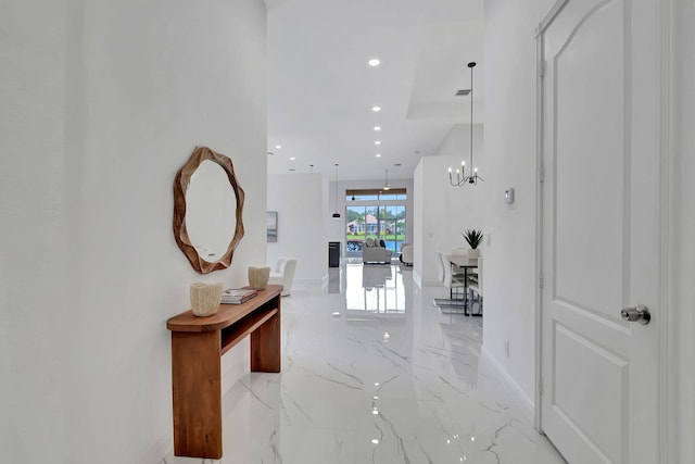 hallway with an inviting chandelier