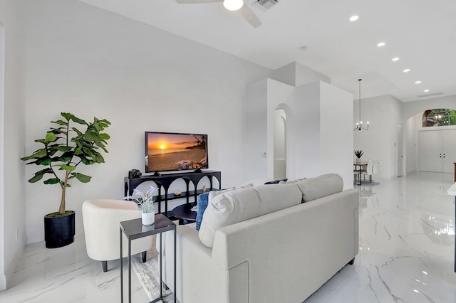 living room featuring ceiling fan with notable chandelier