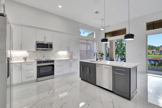 kitchen with white cabinets, stainless steel appliances, and pendant lighting