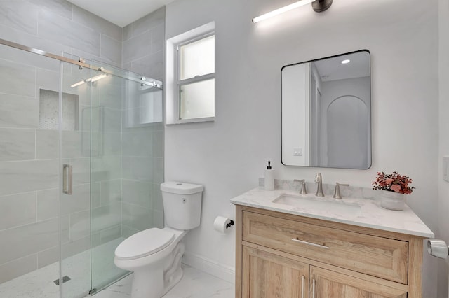 bathroom featuring vanity, toilet, and a shower with door