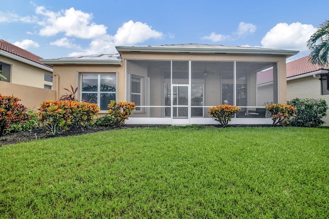 back of house with a lawn and a sunroom