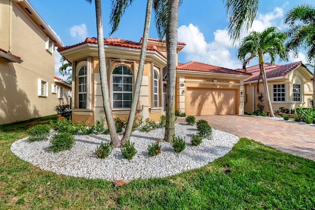 mediterranean / spanish-style house with a garage and a front yard